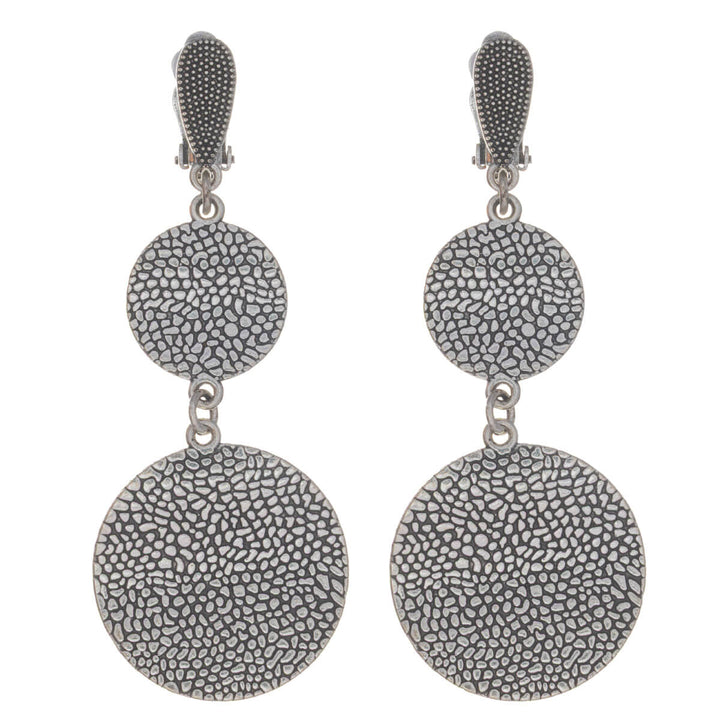 Platta ringar som hänger i klämörhängen